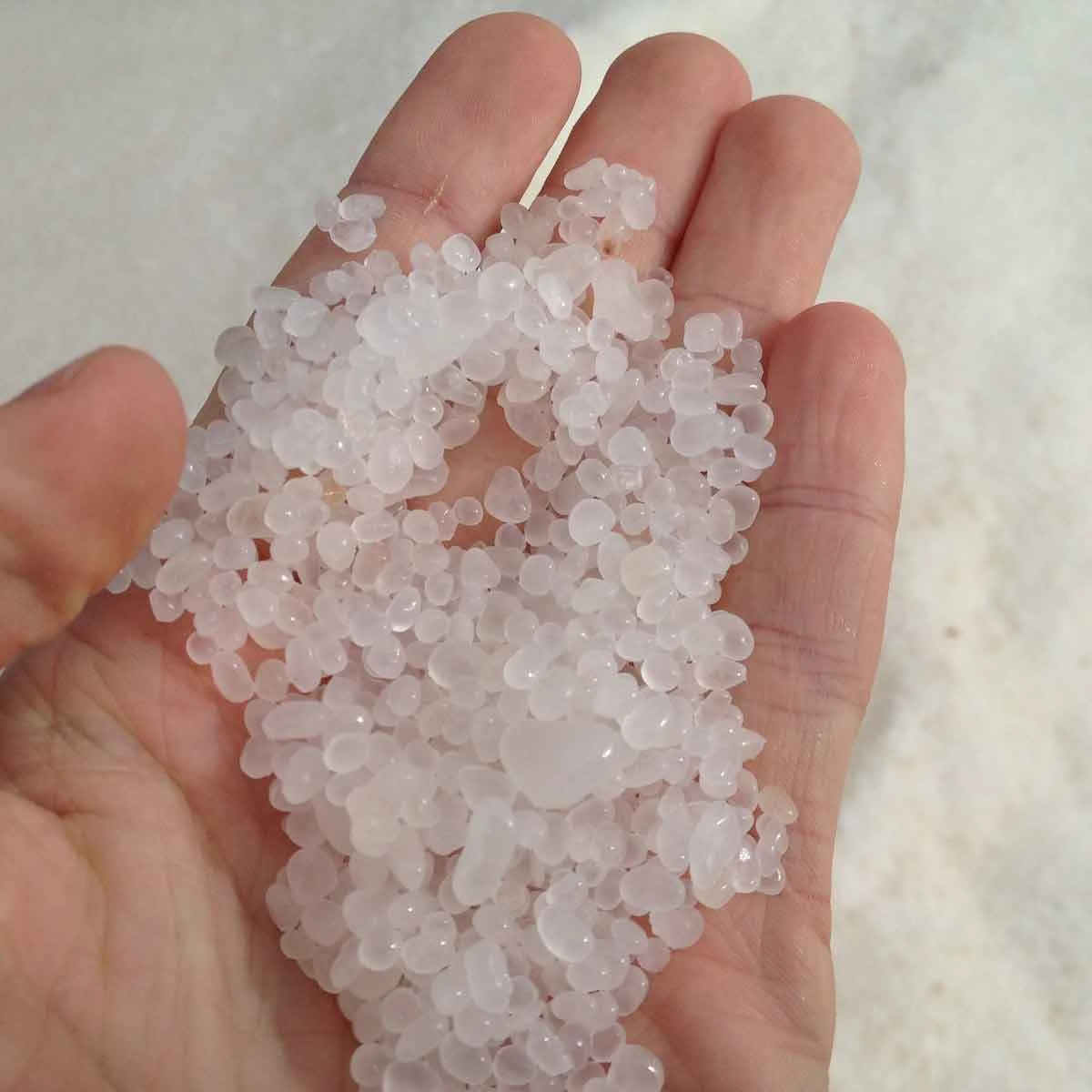 Hand greift nach feinem Perlsalz